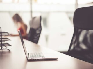 Laptop on Wooden Desk in Office Open Space